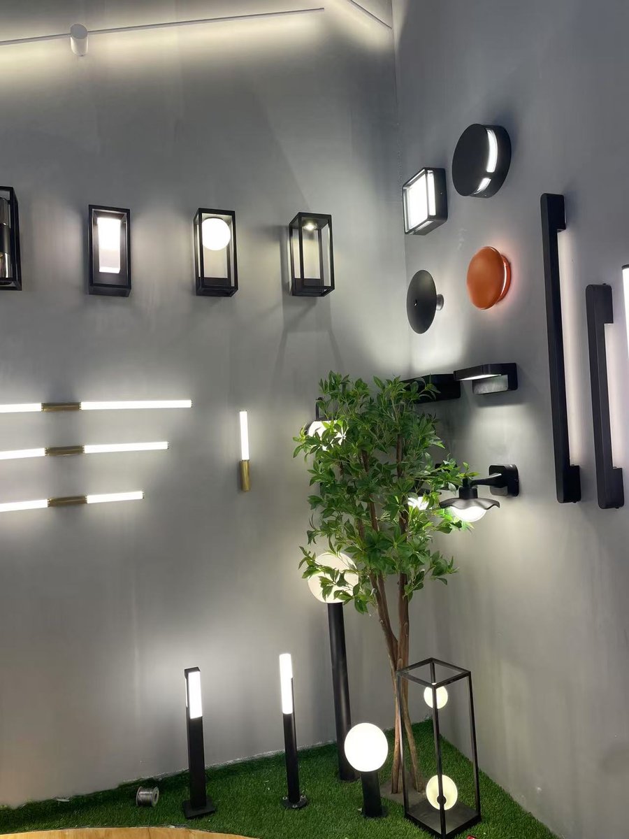 The corner wall — wall lights, linear bars and globe floor lamps lit together