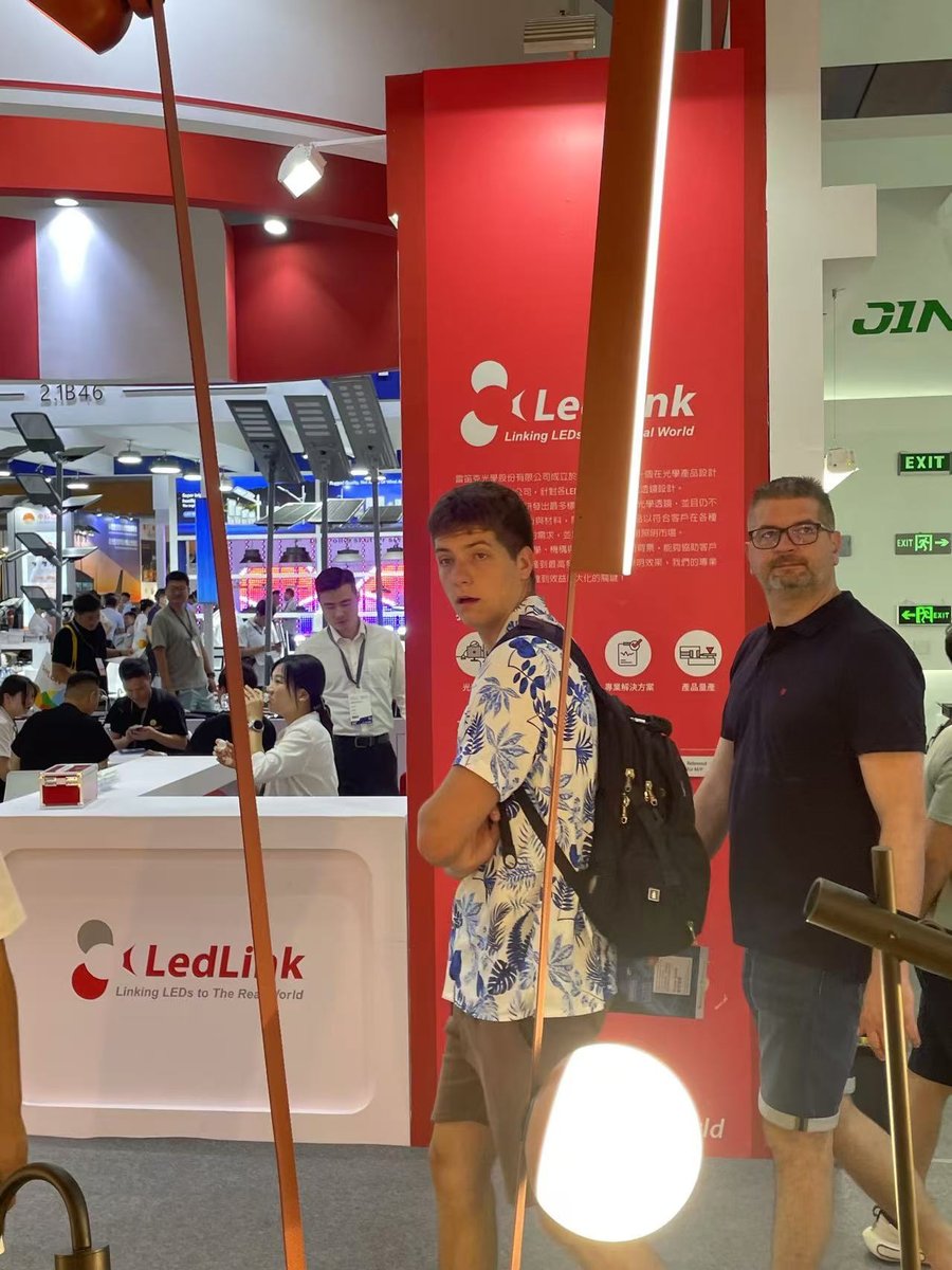In the aisle — overseas buyers passing, mushroom lights in the foreground