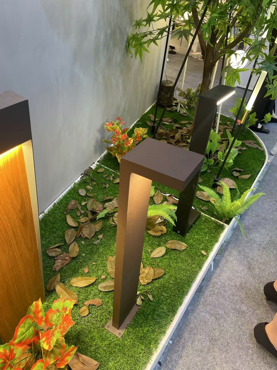 Looking down on the bollards — square and round bodies lighting turf and ground cover